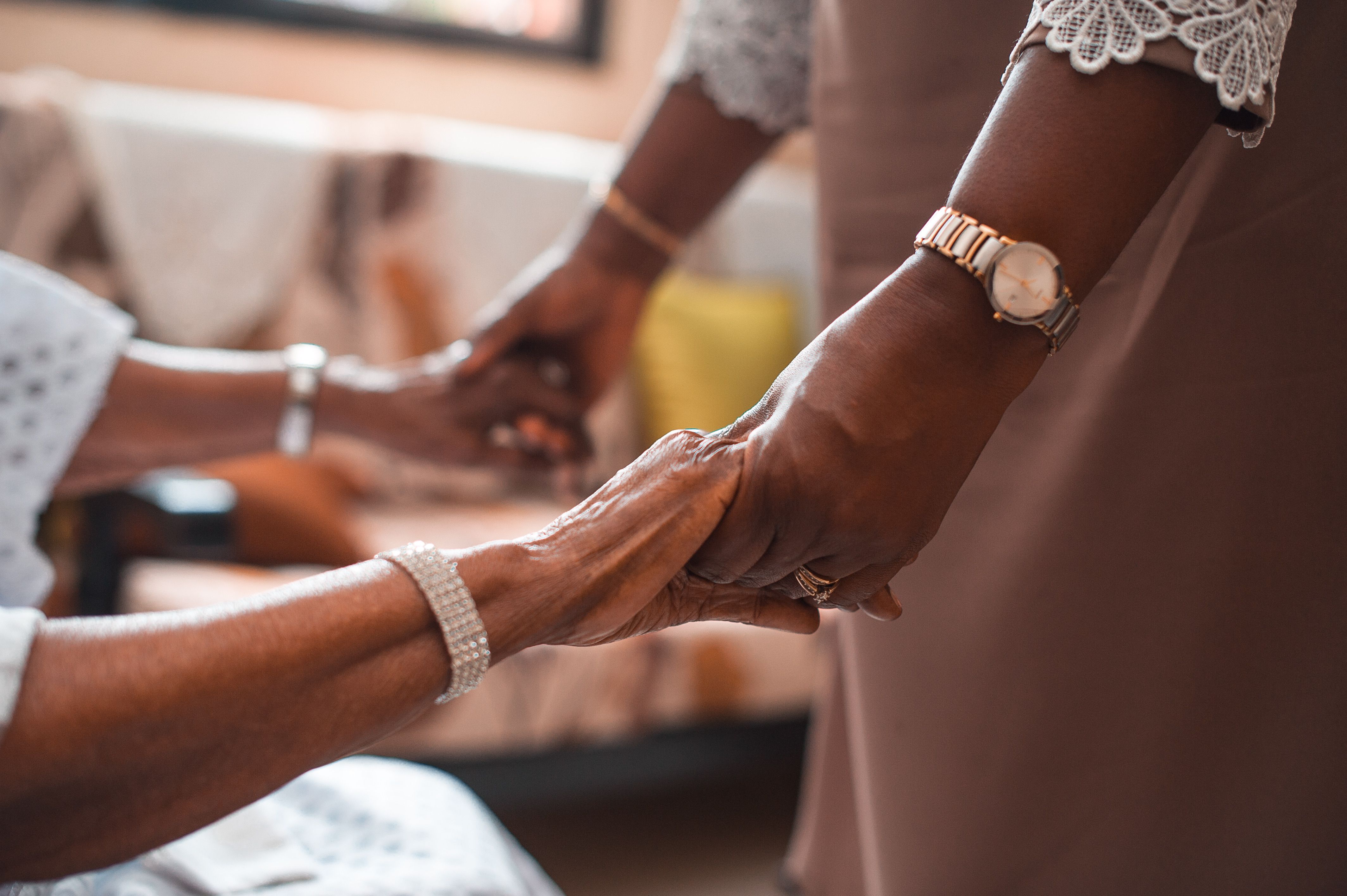 Two people holding hands in a supportive gesture.
